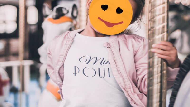Kid on a merry-go-round with a smiley sticker on face to protect privacy - no French kids on social media