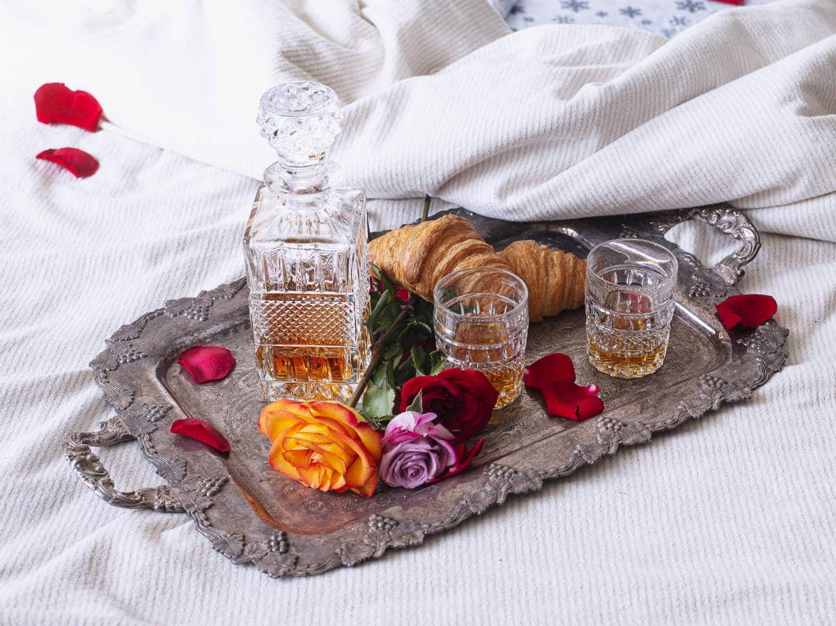 french view of sex: a croissant and digestif sitting on a silver tray in bed