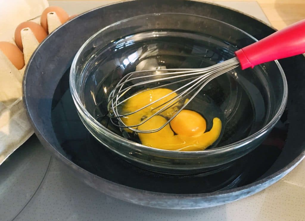 Bain marie of egg yolks in a larger wok pan