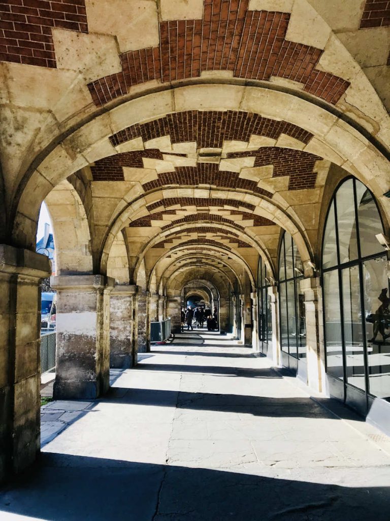 a long corridor in Place des Vosges in Paris