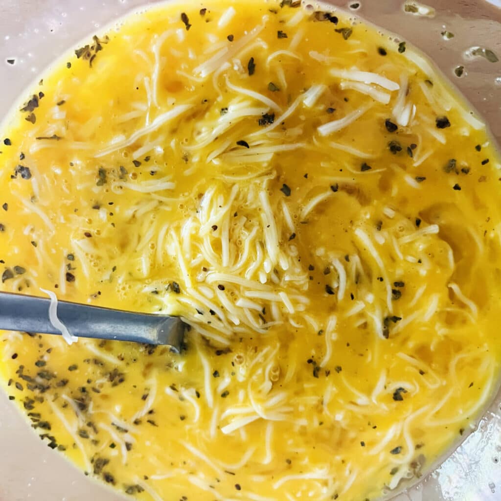 Mixing the eggs and cheese in a bowl