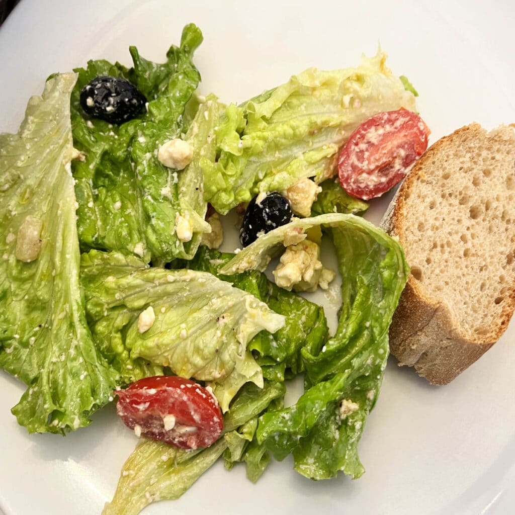 Salad with olives, feta, cherry tomatoes and a piece of baguette