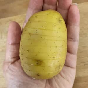 Cutting the hasselback potato in the palm